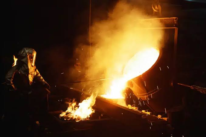 molten metal poured from a ladle into a mold in a foundry