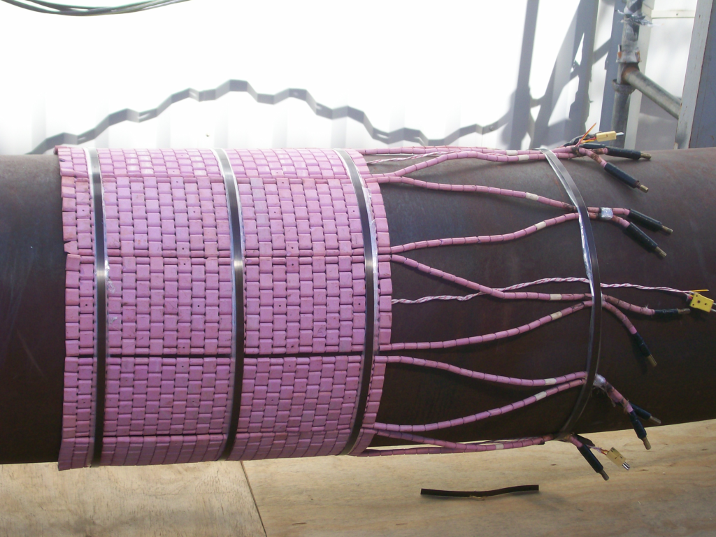 pipe weld wrapped in heating pads and insulation for post weld heat treatment